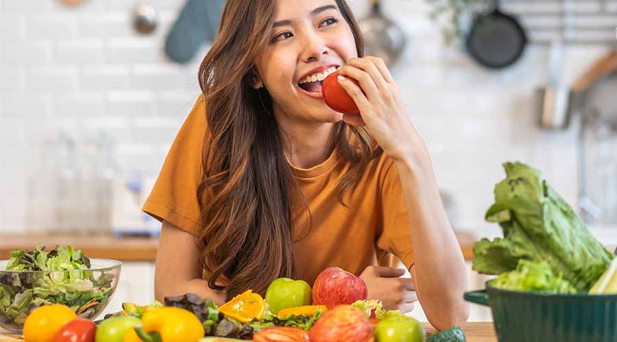 Jeune femme dégustant une salade équilibrée, illustrant le lien entre alimentation saine et beauté naturelle de la peau soutenue par les soins bio aux oligo-éléments IUM Paris.