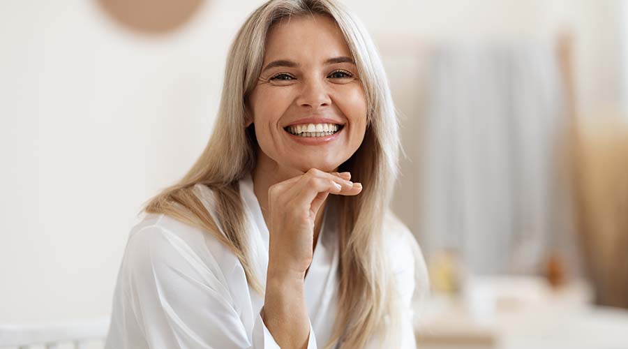 Femme charmante blonde de face qui sourit dans un salon d'esthétique