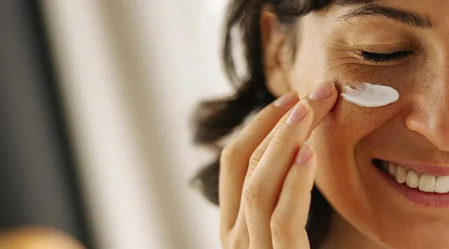 Femme appliquant un soin contour des yeux pour atténuer cernes et poches, illustrant les bienfaits des actifs naturels et minéraux des soins IUM Paris.