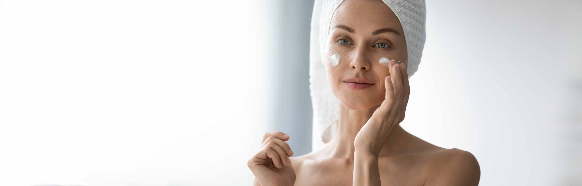Woman applying a face cream in an IUM Paris organic and vegan skincare routine, illustrating the effectiveness and gentleness of natural formulas for all skin types.