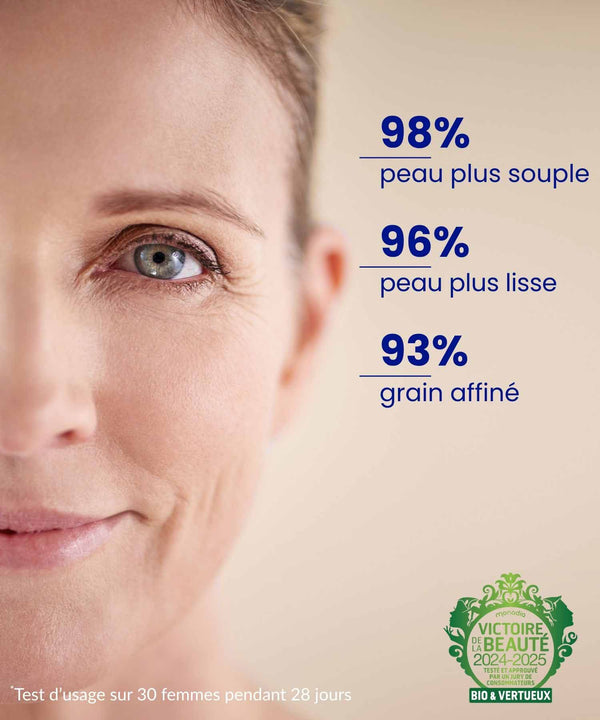 A pretty mixed-race woman smiles as she applies the ium paris mineral scrub mask in a bathroom.