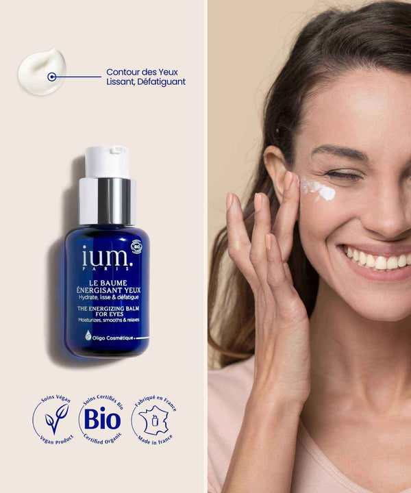 anti cerne bio femme brune applique baume contour des yeux ium sur le visage en souriant