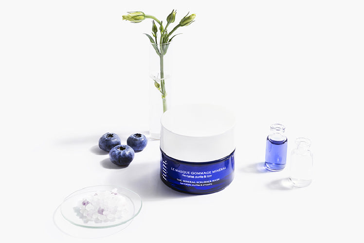 Nature morte du masque gommage pot bleu ium sur fond blanc avec minéraux de silicium et plantes