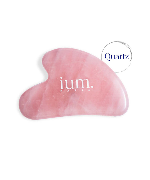Gua Sha stone in ium rose quartz on white background