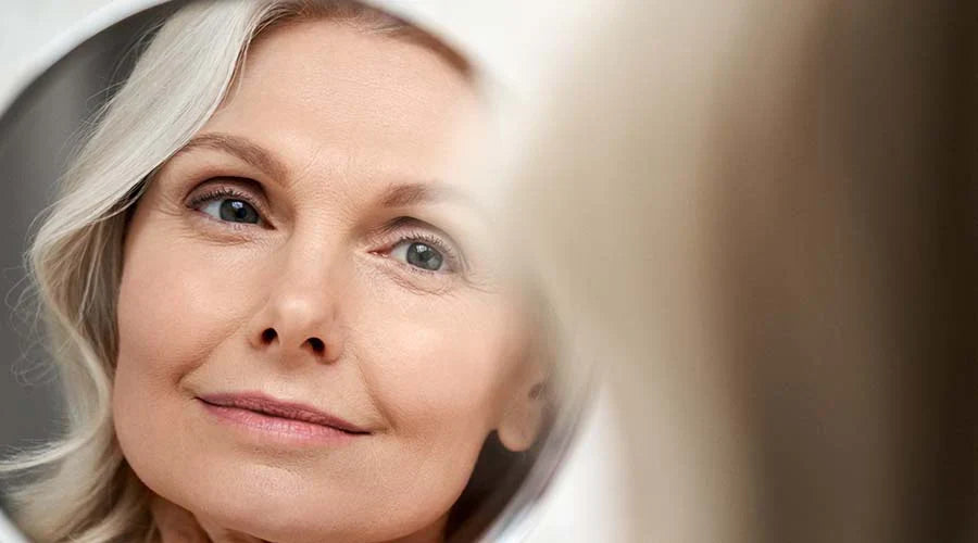 Femme souriante en tenue d’hiver, illustrant la protection de la peau contre le froid et l’importance des soins minéraux IUM Paris pour préserver confort et éclat en saison froide.