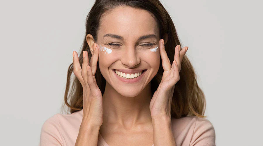 Femme souriante appliquant un soin contour des yeux naturel IUM Paris, symbole d’une peau apaisée et éclatante grâce aux oligo-éléments et minéraux essentiels.