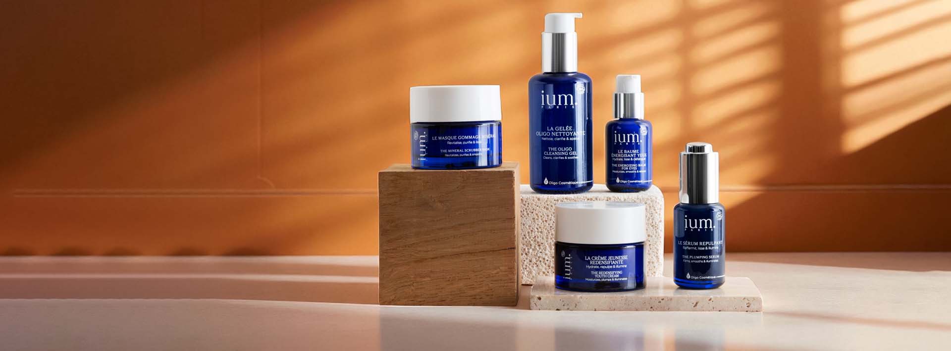 Gamme complète de soins visage IUM Paris à base d’oligo-éléments, flacons en verre bleu recyclables.